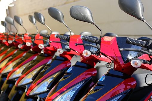 Gold Coast, Australia - October 6, 2016: Details of a row of red scooters. These scooters are for hire at a holiday destination