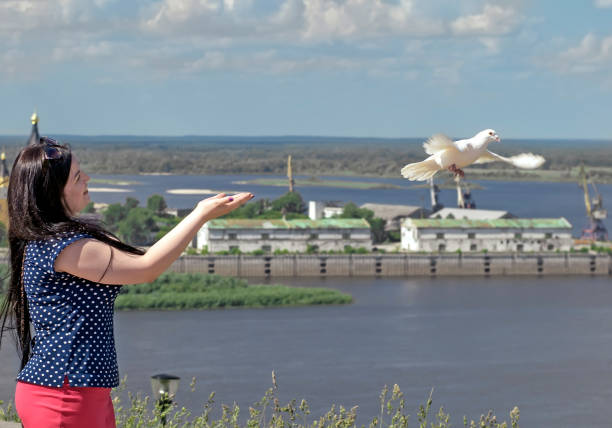 The girl released a dove from the hands on the background of Nizhny Novgorod, Russia