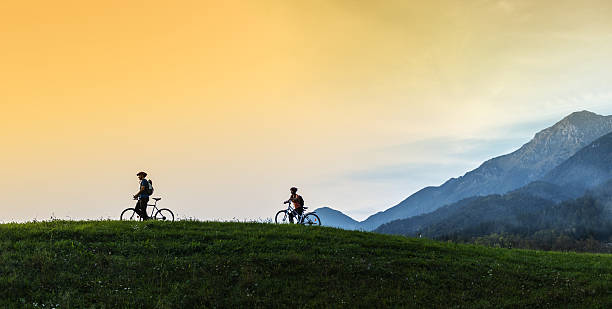 young happy couple riding bicycles  in nature - sport exercising men julian alps imagens e fotografias de stock