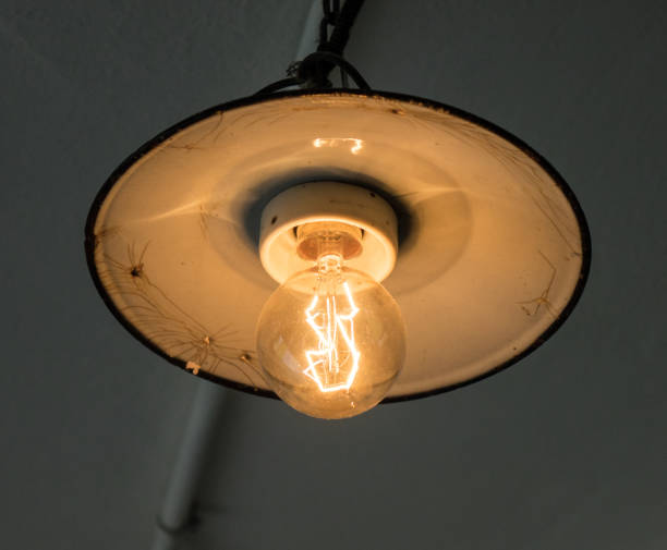 istock Lighting light bulb on the cable in dark room 638295724