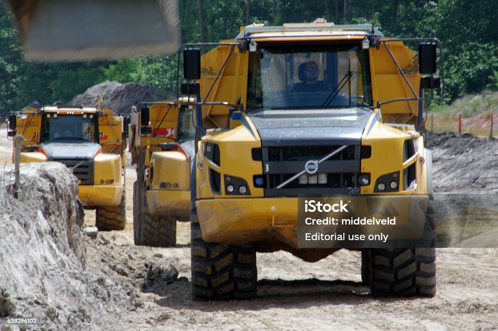 Heavy dumpers in line Landgraaf, the Netherlands - June 23, 2016: Heavy dumpers in line near a road construction. End of the year the project must be ready. Activity Stock Photo