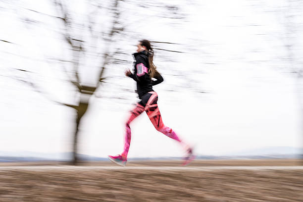 Young woman running through the park.
