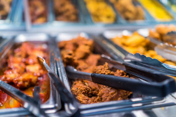 Soup warmers with stainless steel lids and serving ladles at a hotel buffet, maintaining hot soups and stews for guests in a cozy dining environment.