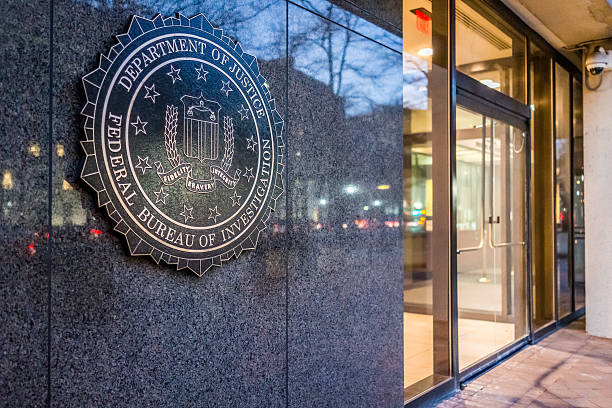 FBI, Federal Bureau of Investigation Headquarters, on Pennsylvania avenue Washington Dc, United States - December 29, 2016: FBI, Federal Bureau of Investigation Headquarters, on Pennsylvania avenue sign with traffic reflections at night coat of arms photos stock pictures, royalty-free photos & images