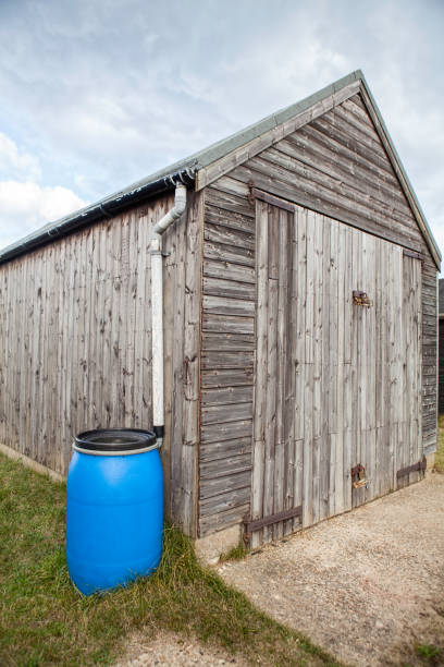 istock Blue plastic water butt attached to wooden shed 638303698