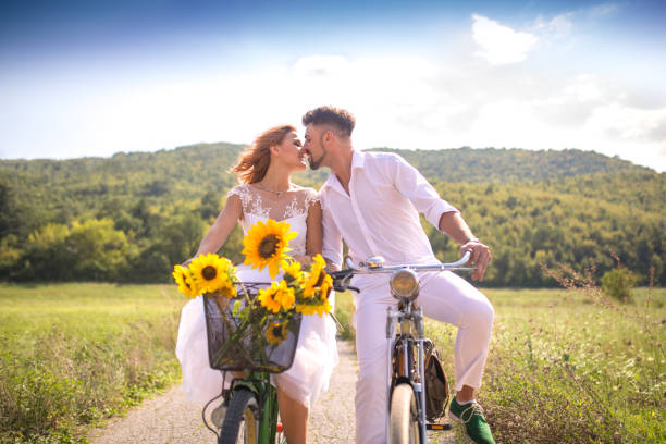 baiser d’un jeune couple romantique à vélo - sunflower field single flower flower photos et images de collection