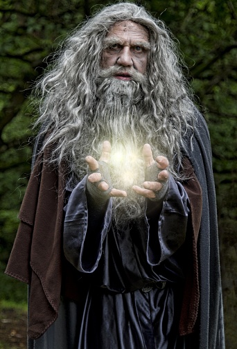 Wizard casting a light spell. Model has long grey unkempt hair and beard,