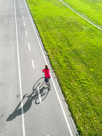 Overhead view of a woman cycling in a recreational area in Barcelona. Spain.