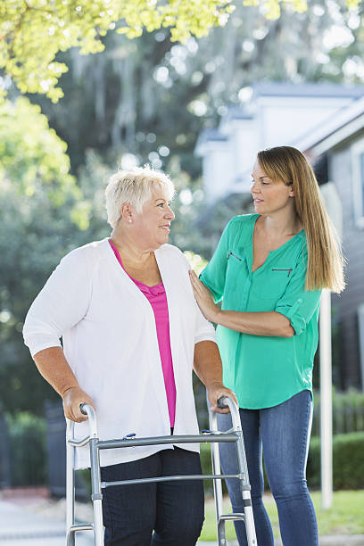 istock Women helping her mother use walker 638309482