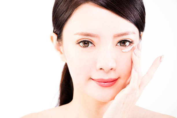 istock young woman applying skin cream under eyes 638310058