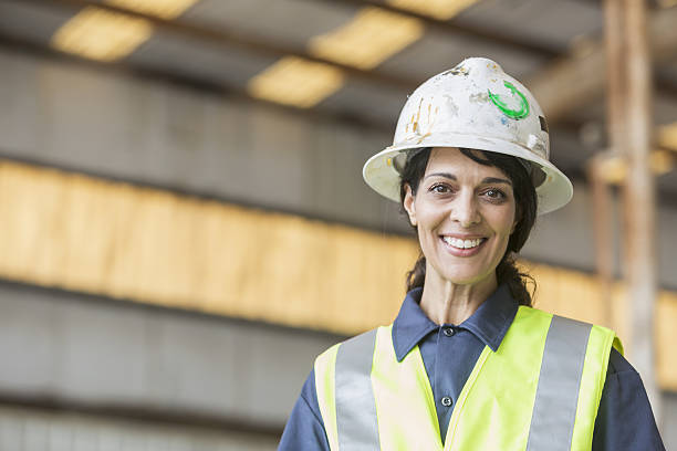 istock Hispanic female worker wearing hardhat and safety vest 638312390