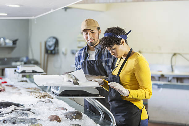 Young mixed race couple working in fish market