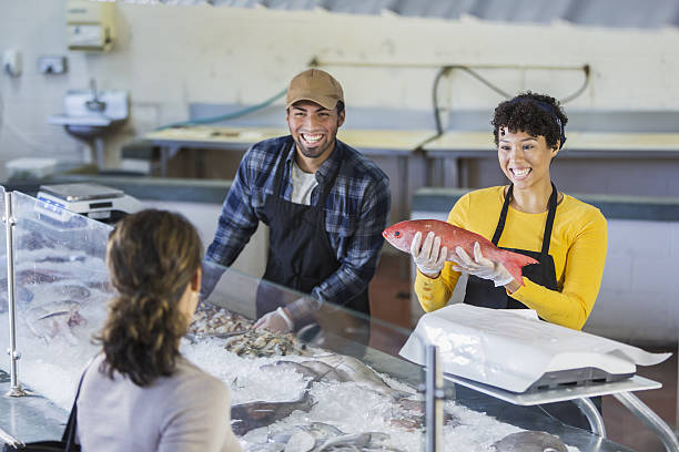 istock Workers in seafood market helping customer 638312468