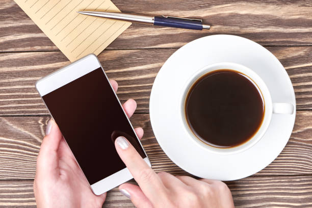 istock Womans hands with smartphone and cup of coffee 638315098
