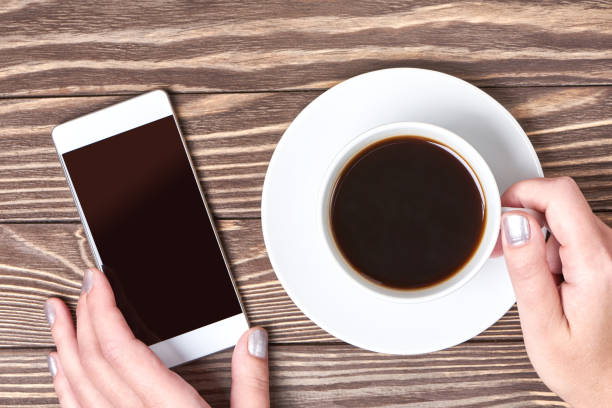 istock Womans hands with smartphone and cup of coffee 638315402