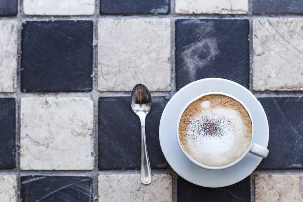 istock Cappuchino in white cup on stone squared background 638315490