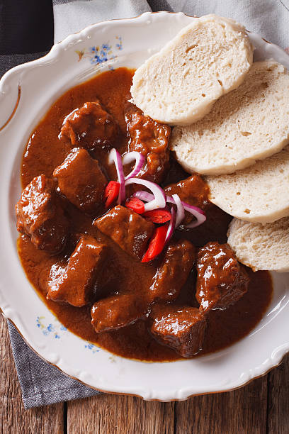 istock Thick goulash with dumplings on a plate close-up. vertical 638320806