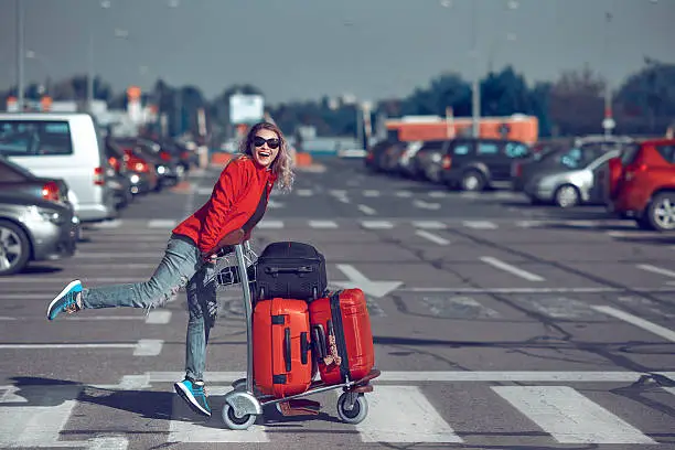 lifestyle shot of happy woman carrying her luggages, laughing and feeling great in her vacation.