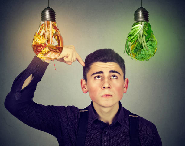istock man looking up at junk food vegetables light bulb 638330458