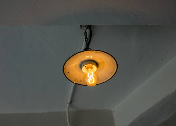 istock Lighting light bulb on the cable in dark room 638332860