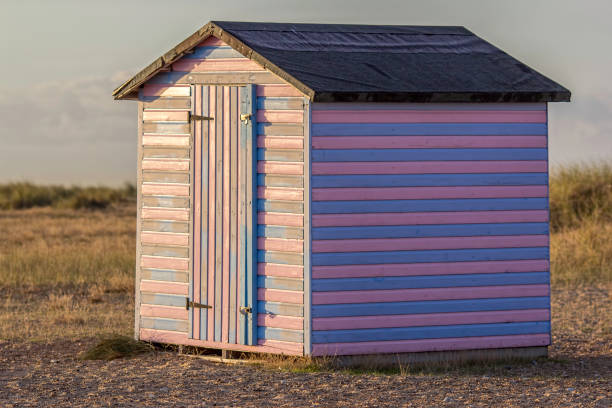 istock pink and blue striped beach hut at sunrise 638332896