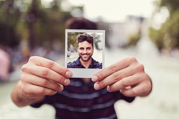 istock Young man showing instant photo 638333848
