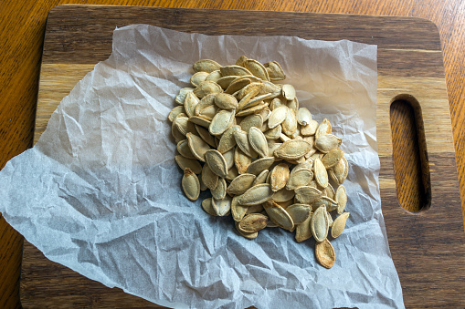 Grilled Pumpkin seeds with sea salt and spices on the wooden background