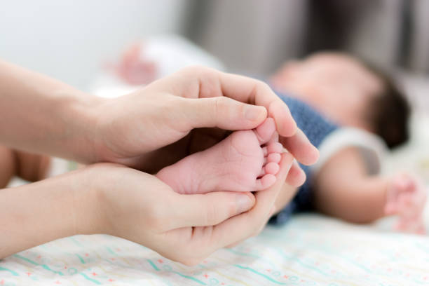 istock Baby's feet in mothers hands with copy space 638336440