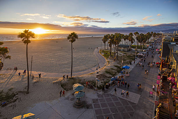 日没時にビーチで歩道を歩く観光客 - カリフォルニア州 ベニス ストックフォトと画像