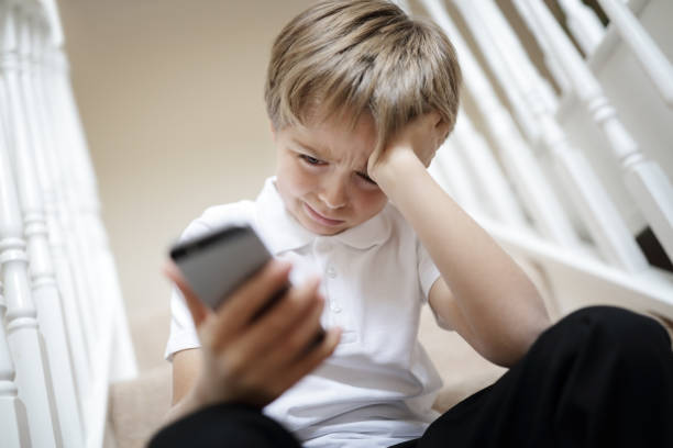 cyber bullismo tramite sms telefonico - bullying child teasing little boys foto e immagini stock