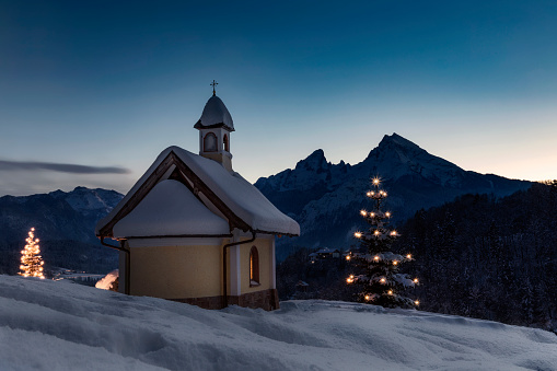 Panoramic view of beautiful winter wonderland mountain scenery in the Alps with pilgrimage church of Jamnik and famous Julian Alps in the background, Slovenia Christmas time in Europe