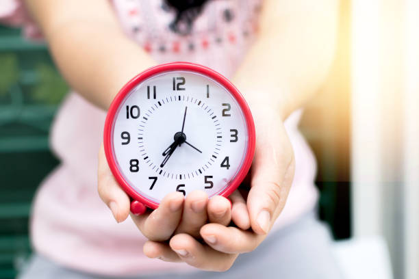 istock Holding red clock on hand and giving this to you. 638351486