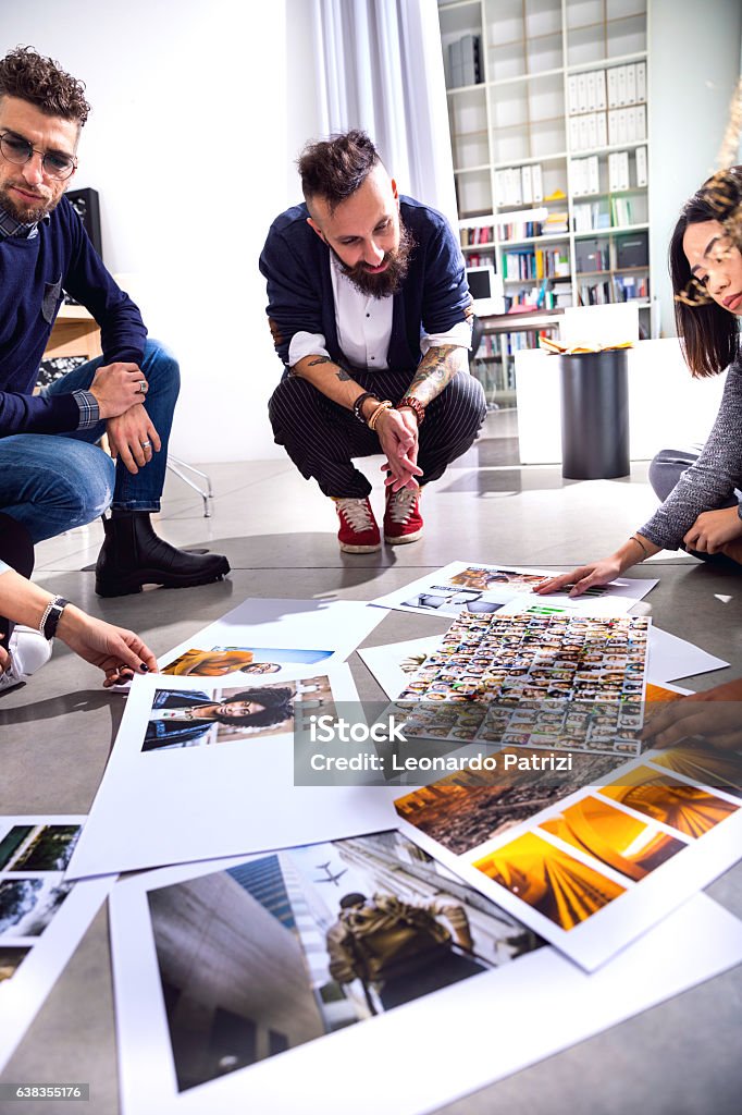New faces to advertise our brand new product New Business office team at work together on tasks choosing the right image to use in a campaign. Art Director Stock Photo