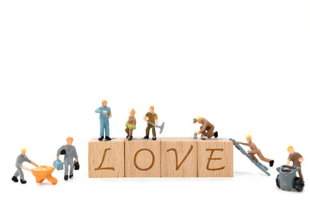 istock Miniature worker team building word love on white background 638357342
