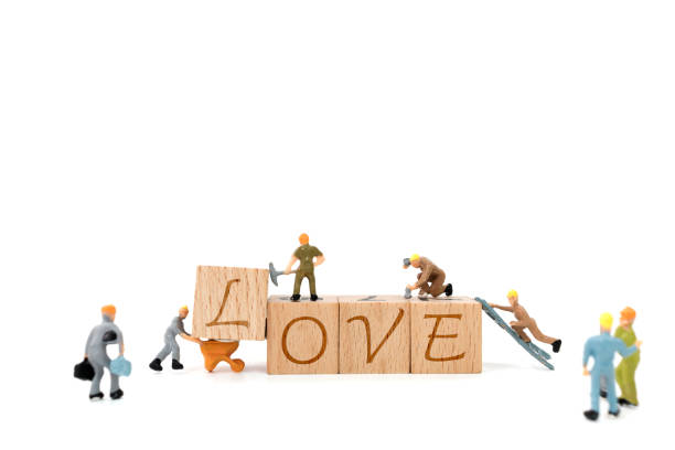 istock Miniature worker team building word love on white background 638357366