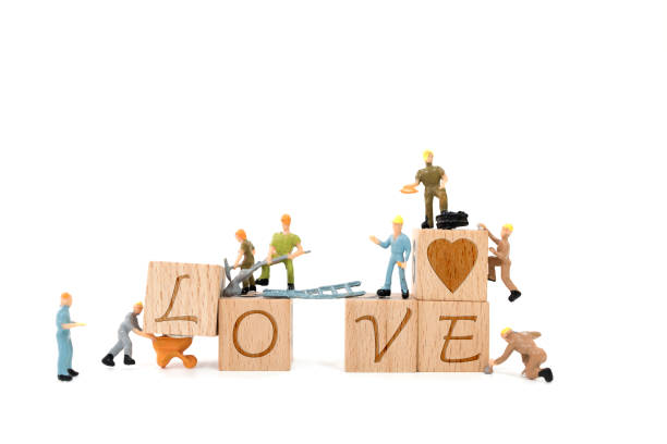 Miniature worker team building word love on white background