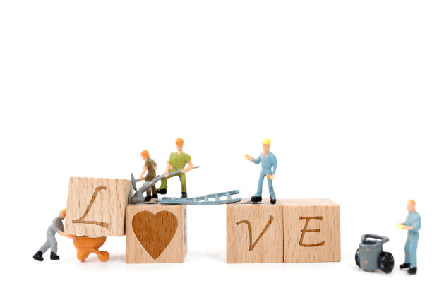 istock Miniature worker team building word love on white background 638357418