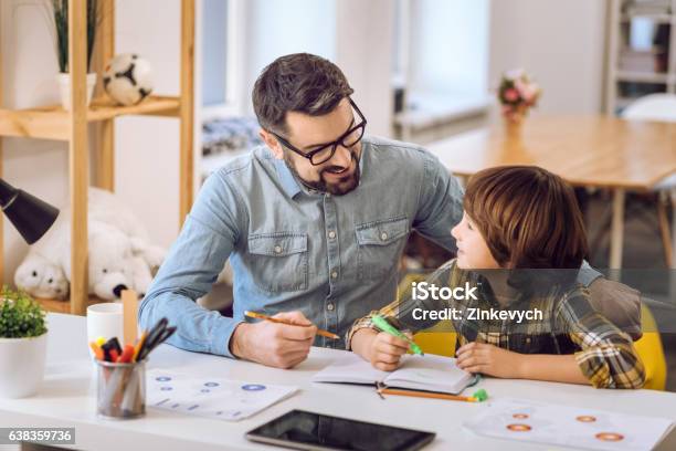 Handsome Man Doing Tasks With His Son Stock Photo - Download Image Now - Father, Son, Homework