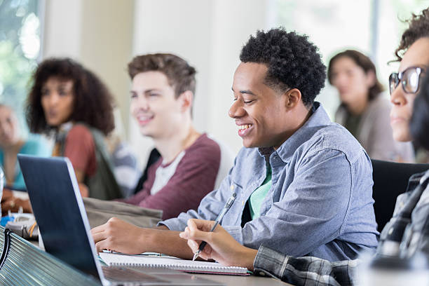 istock Handsome African American male college student takes notes in class 638360436