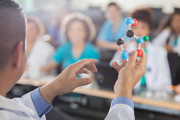 istock Male medical school professor teaches students about molecular structure 638361044