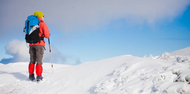 istock Girl with backpack walking on snow in the mountains. 638361170