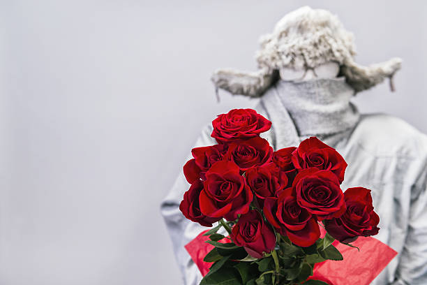 Frozen man presenting a bouquet of  a dozen red roses