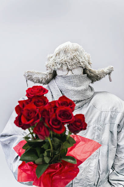 istock Frozen man presenting a bouquet of  a dozen red roses 638363214