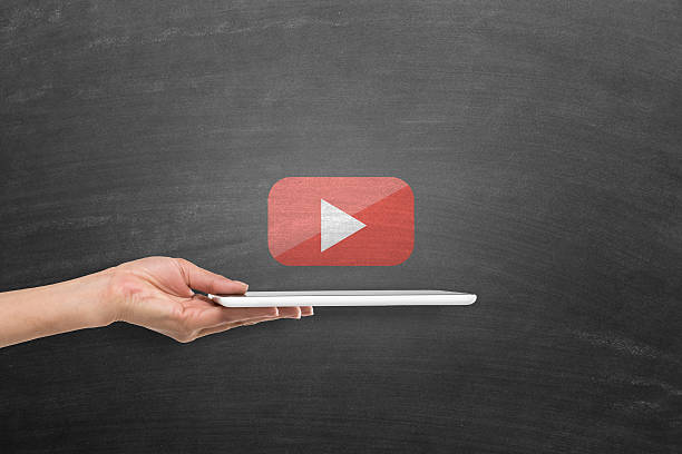 Digital tablet with you tube play icon on blackboard Woman holding digital tablet under you tube play icon on blackboard play button photos stock pictures, royalty-free photos & images