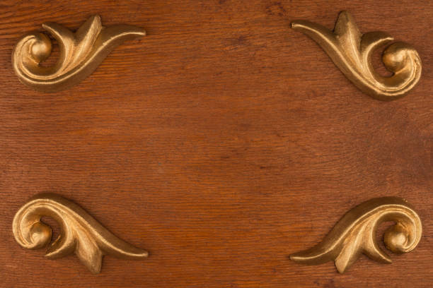 Luxury frame made of golden stucco plaster, lying on a dark wood. With space for your text