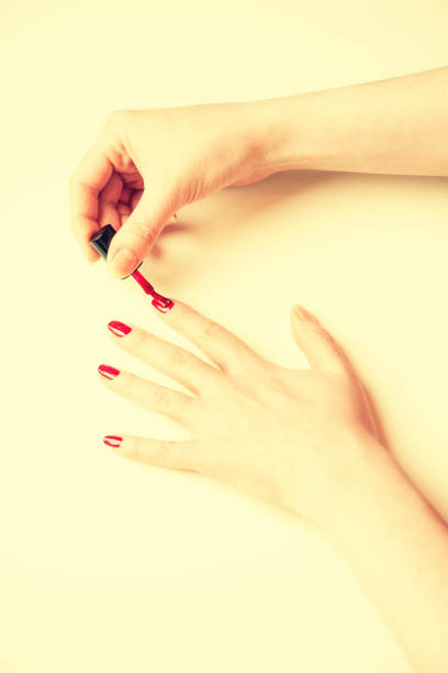 istock Woman hand putting a varnish on nails 638368364