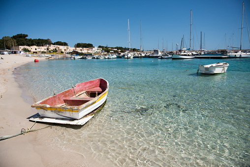 Clear waters of the beach at San Vito lo Capo, Sicily with boat in the foreground