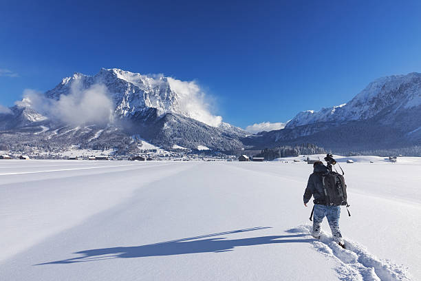 fotografo naturalistico in inverno di fronte al monte zugspitze - zugspitze mountain tirol lermoos ehrwald foto e immagini stock