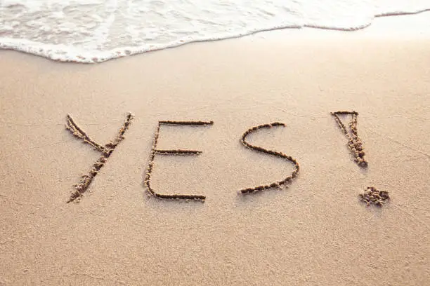 YES concept, positive changes in the life, word written on sand beach