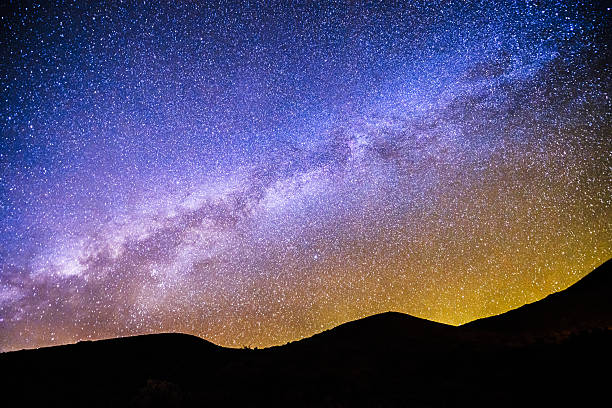 Mauna Kea Milky Way Night Sky Mountain Silhouette Kona Hawaii This is a horizontal, color, royalty free stock photograph of a  multicolored starry night sky with the Milky Way. The edge of the mountains visible at a high elevation at Mauna Kea Kona, Hawaii are silhouetted. The night sky is multicolored gradient filled with stars. Photographed with a Nikon D800 DSLR camera. andromeda galaxy stock pictures, royalty-free photos & images